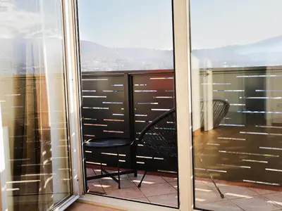 a balcony with a black chair and a view at PENTHOUSE ROYA BiHAC in Bihać