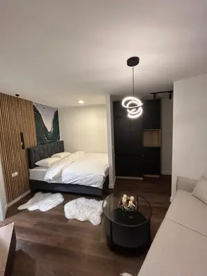 a bedroom with a bed and a coffee table at briliNIGHT in Banja Luka