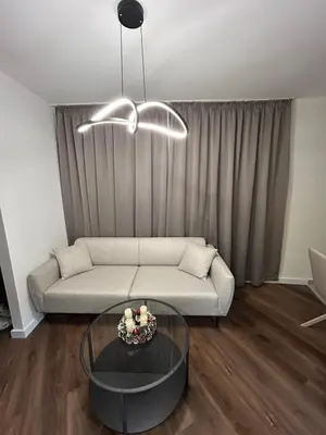 a living room with a couch and a glass table at briliNIGHT in Banja Luka
