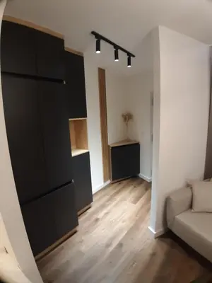 a living room with a couch and a large black cabinet at briliNIGHT in Banja Luka
