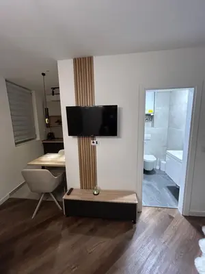 a living room with a television on a wall at briliNIGHT in Banja Luka