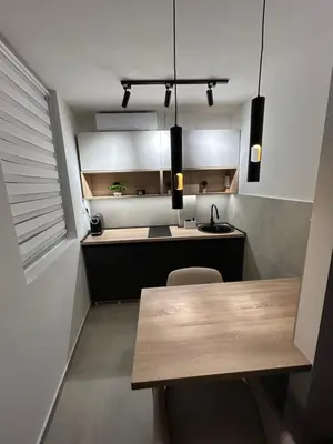 a kitchen with a wooden table and a counter at briliNIGHT in Banja Luka
