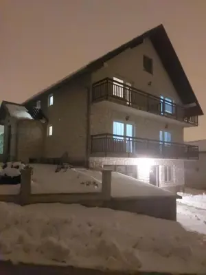 a large building with snow in front of it at Studio apartman KONAK in Kupres