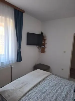 a bedroom with a bed and a flat screen tv at Studio apartman KONAK in Kupres