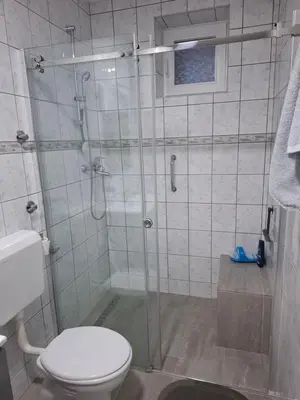a bathroom with a glass shower with a toilet at Studio apartman KONAK in Kupres