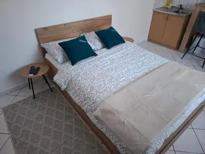 a bedroom with a large bed with blue pillows at Studio apartman KONAK in Kupres