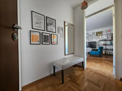 a room with a mirror and a bench on a wall at City Place Apartment in Banja Luka