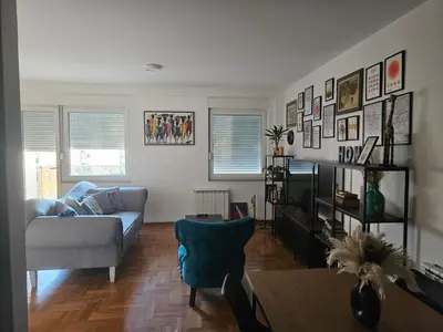 a living room with a couch and a chair at City Place Apartment in Banja Luka
