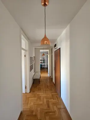 a hallway with white walls and a wooden floor at City Place Apartment in Banja Luka