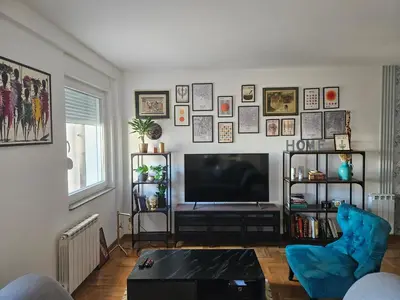 a living room with a flat screen tv on a wall at City Place Apartment in Banja Luka