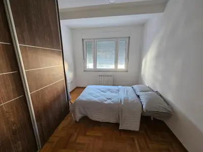 a small bedroom with a bed and a window at City Place Apartment in Banja Luka