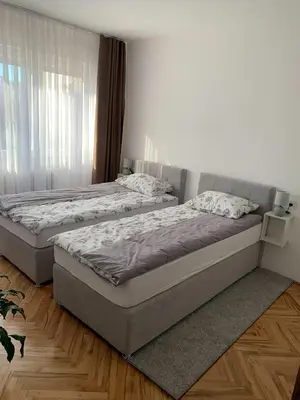 two twin beds in a bedroom with wooden floors at Apartment Vilsonova in Banja Luka