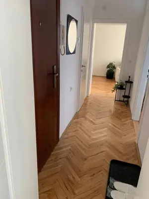 a hallway with a wooden floor and a door at Apartment Vilsonova in Banja Luka