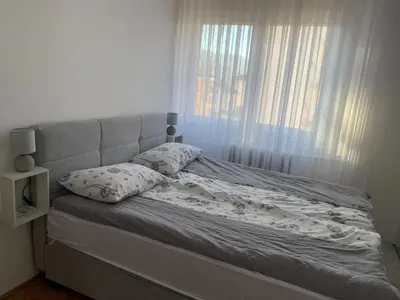 a bed with white sheets and pillows in a bedroom at Apartment Vilsonova in Banja Luka