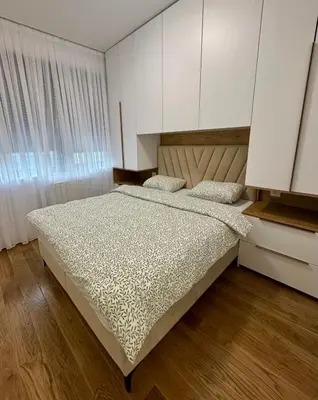a bedroom with a large bed with white cabinets at Apartman GrandTrade by Termax in Banja Luka