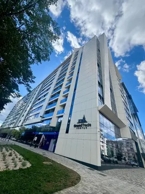 a tall white building with a sign on it at Apartman GrandTrade by Termax in Banja Luka
