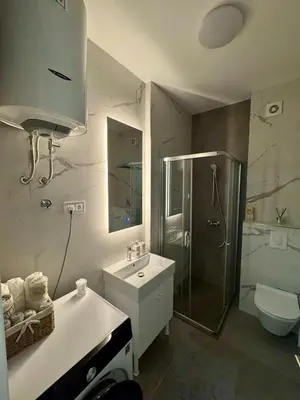 a bathroom with a sink and a shower and a toilet at Apartman GrandTrade by Termax in Banja Luka