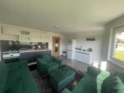 a living room with a couch and chairs and a kitchen at Zanesovici Jezero in Bugojno