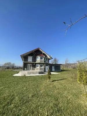 a large house in a field with a grass yard at Zanesovici Jezero in Bugojno