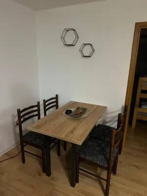 a wooden table with chairs and a plate on it at Apartman Nina in Šišava