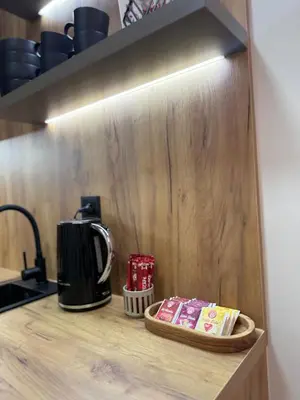 a counter top with a coffee pot and books on it at CENTRAL SQUARE Tuzla in Tuzla