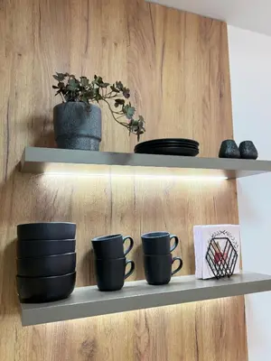 a shelf with black cups and plates on it at CENTRAL SQUARE Tuzla in Tuzla