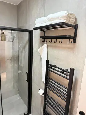 a bathroom with a shower and a towel rack at CENTRAL SQUARE Tuzla in Tuzla