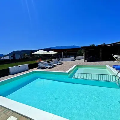 a large swimming pool with blue water in a yard at Villa Leah in Bihać