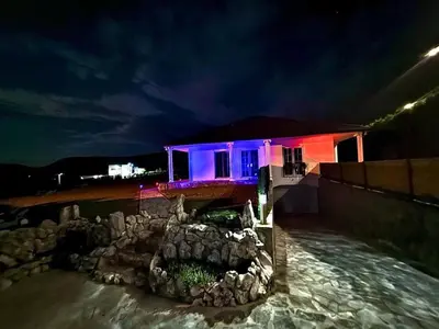 a house with blue and purple lights on it at Villa Leah in Bihać