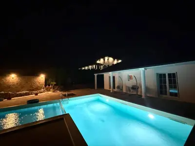 a swimming pool at night in front of a building at Villa Leah in Bihać