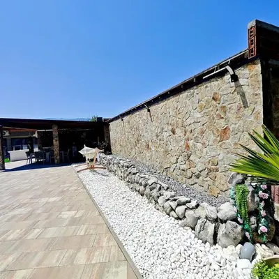 a stone wall with a bench next to a patio at Villa Leah in Bihać