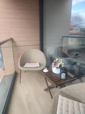 a wicker chair and a table on a balcony at Banja Residence Apt in Tuzla