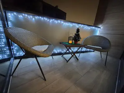 two chairs and a table in a room with lights at Banja Residence Apt in Tuzla