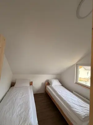 two beds in a small room with a window at Vlasic Odmor - Villa Amina in Vlasic