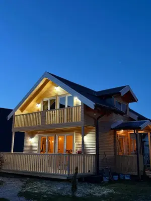a wooden house with lights on it at night at Vlasic Odmor - Villa Amina in Vlasic