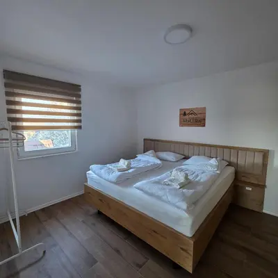 a bedroom with a bed with white sheets and a window at MaLi Raj in Vlasic
