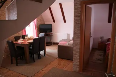 a dining room and living room with a table and chairs at Apartmani Ciro in Kupres