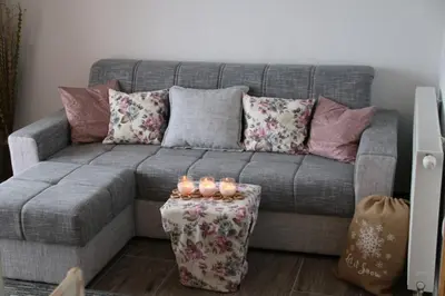 a living room with a gray couch with candles on a table at Apartmani Ciro in Kupres