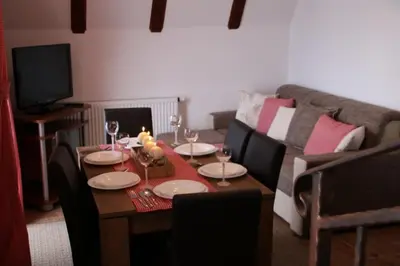 a living room with a table with wine glasses and a couch at Apartmani Ciro in Kupres