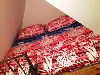 a bed with red and white sheets and pillows at Kuća za odmor Vukas in Kupres