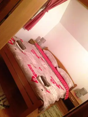 a bedroom with a bed with pink sheets and pillows at Kuća za odmor Vukas in Kupres