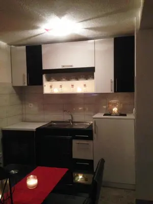a kitchen with black and white cabinets and a red table at Kuća za odmor Vukas in Kupres