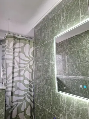 a bathroom with a shower curtain and a window at Apartman Mila in Bihać