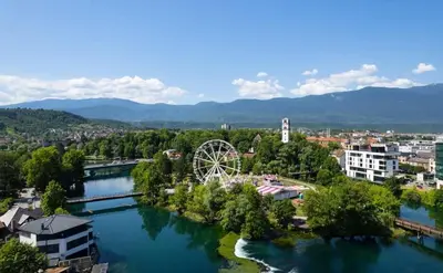 a city with a river and a ferris wheel at Apartman Mila in Bihać