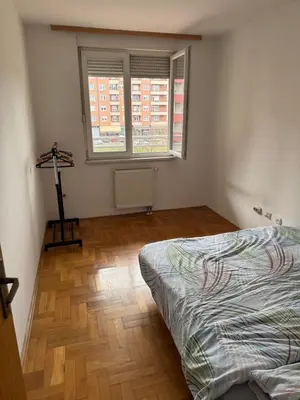 a bedroom with a bed and a wooden floor at Jedinica in Banja Luka