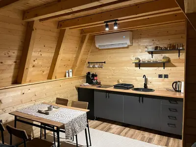 a kitchen with wooden walls and a table with a sink at Cottage Soul Rest