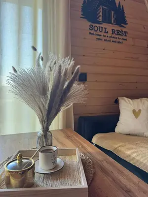 a table with a cup of coffee and a vase with feathers at Cottage Soul Rest