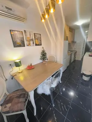 a kitchen with a wooden table and two chairs at City Center Apartment in Banja Luka