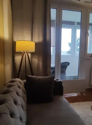 a living room with a couch and a lamp at City Center Apartment in Banja Luka