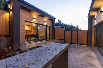 a modern house with a concrete bench in the courtyard at BLOK Wood Cottage in Ivišovo Greblje